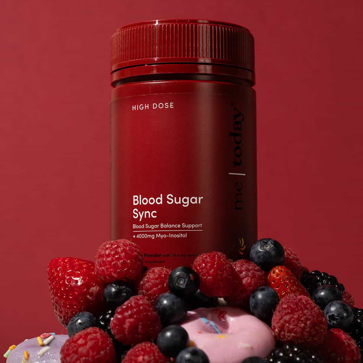 Red supplement bottle labeled 'Blood Sugar Sync' with berries on a red background