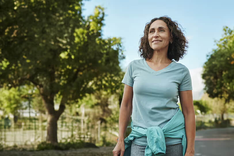 Middle aged woman walking outside in athleisure.