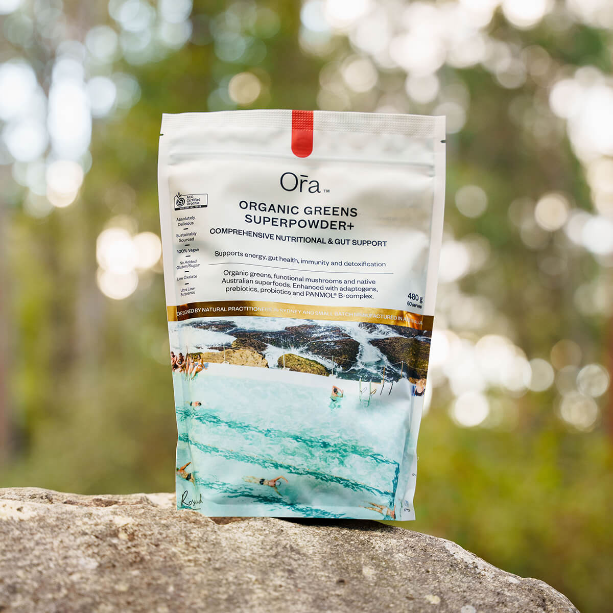 Ofa Organic Greens Superpowder package on a rock with a blurred natural background