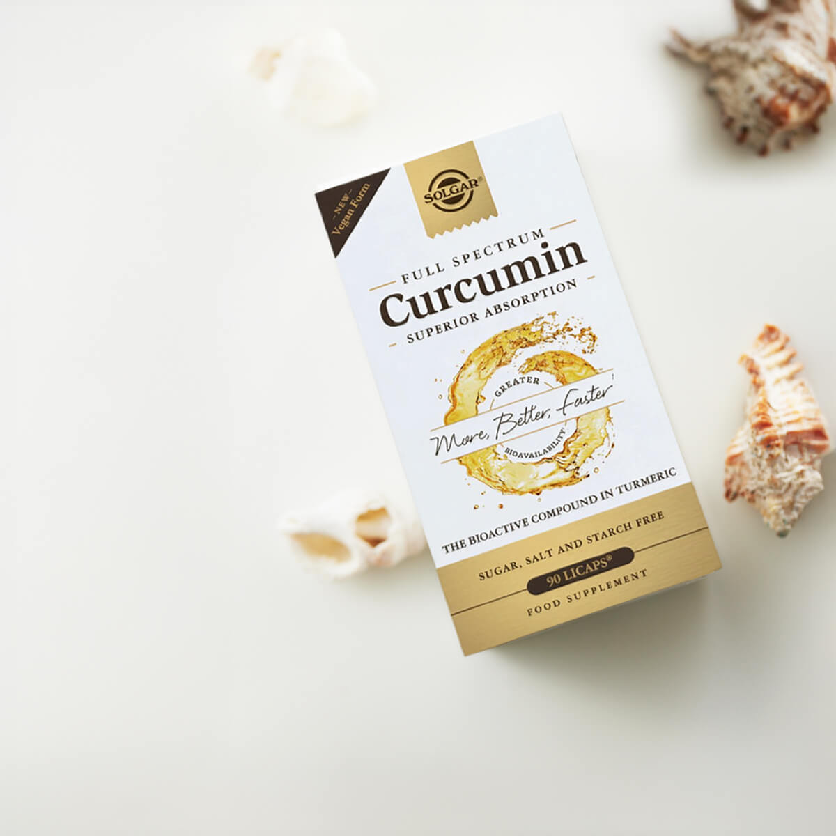 Box of Full Spectrum Curcumin supplement with seashells on a light background.