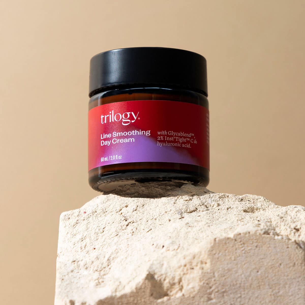 Trilogy Line Smoothing Day Cream jar on a beige background.