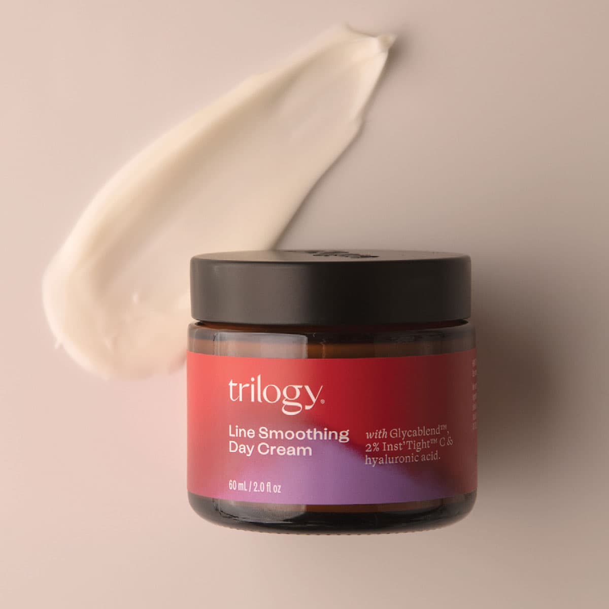 Jar of Trilogy Line Smoothing Day Cream with a swatch on a beige background.