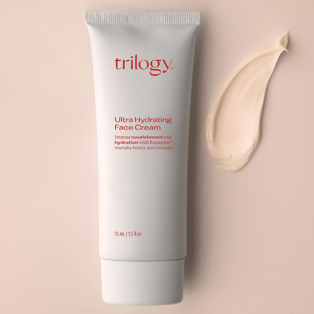 Trilogy Ultra Hydrating Face Cream tube on a beige background.