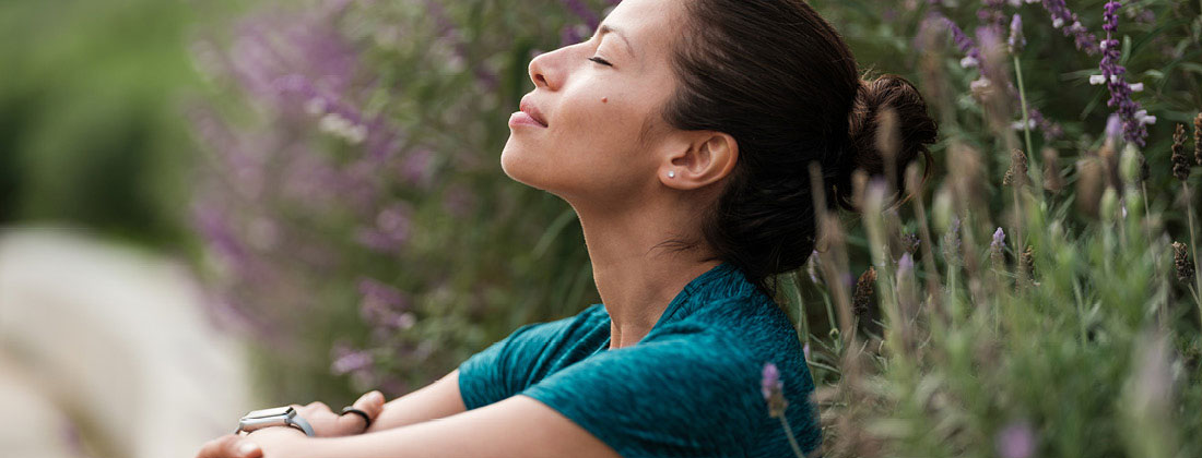 Woman Sits In Nature With Eyes Closed