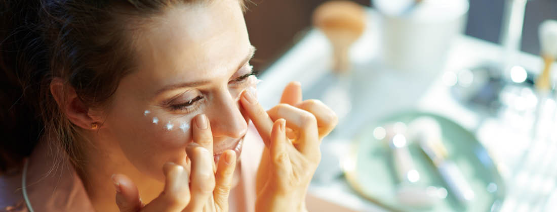 A woman applying sunscreen to her face