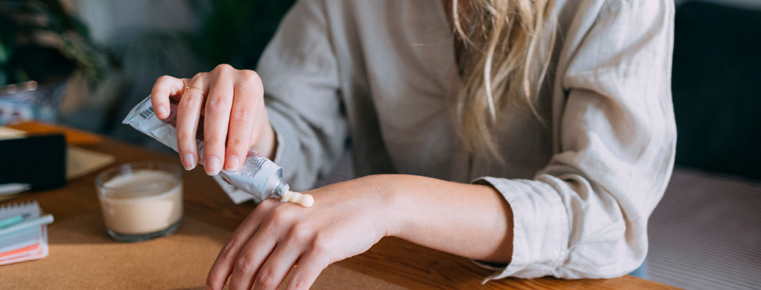 Woman squeezes hand cream out of tube