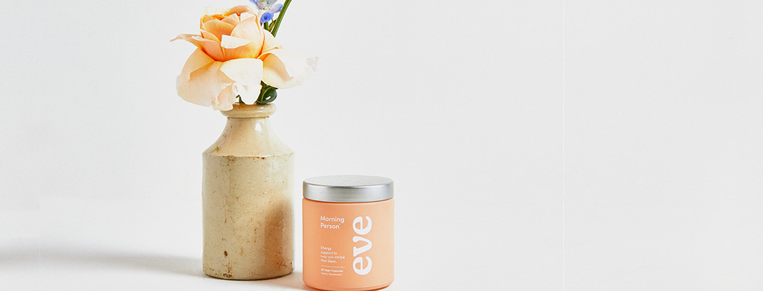 Eve Wellness new product Morning Person sits next to a vase of flowers