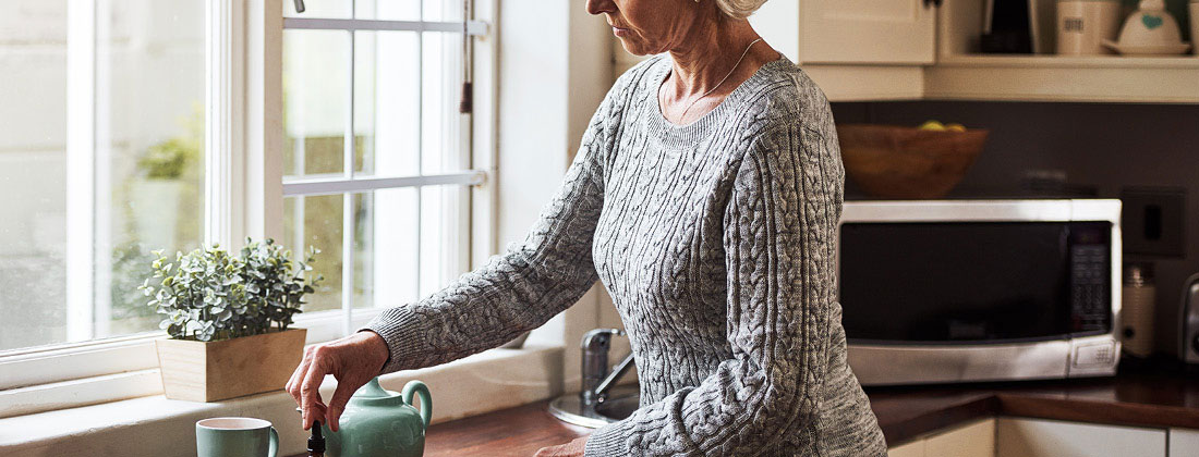 woman makes tea in kitchen