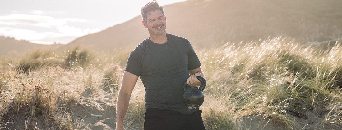 Man Smiles Doing Exercise Outdoors At Beach
