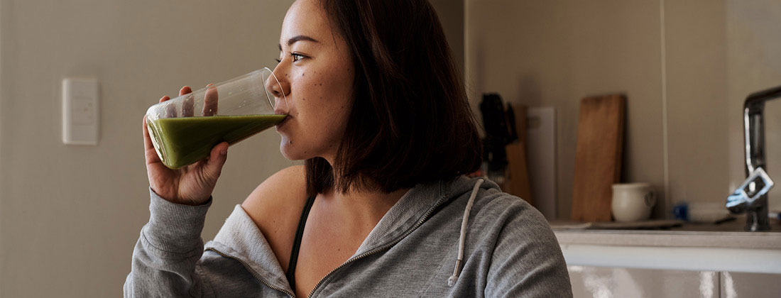 Woman drinks healthy green drink