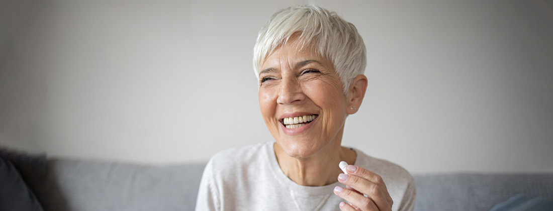 Woman smiling taking a supplement for skin health