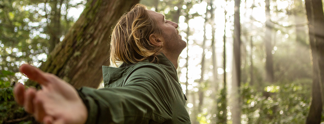 Man Stands Surrounded By Nature And Sunlight 