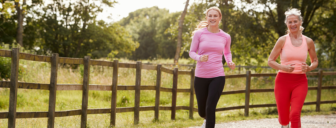 younger and older women jogging looking happy