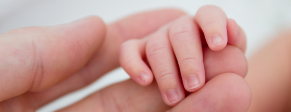 Mother holding babies hand